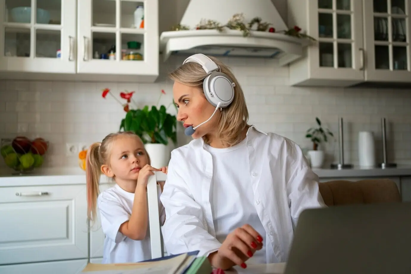 Mutter arbeitet von zu Hause und versucht, Familienleben mit Kind und Beruf zu vereinbaren.
